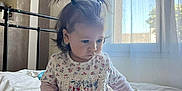 Dunja a rejoint le concours — aidez-le/la à gagner de superbes lots ! toddler, child, bed, pigtails, toys, window, curtain, natural_light, indoor, clothing, socks, blue_leggings, floral_top, person, cute, young_child, playing, home, soft_light, focused