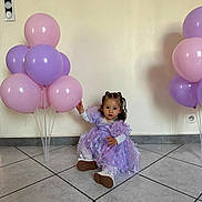 Dunja a rejoint le concours — aidez-le/la à gagner de superbes lots ! balloons, celebration, child, curious, curly_hair, cute, decor, floor_tiles, indoor, lavender_dress, long_sleeve_shirt, party, pink, portrait, purple, sitting, toddler, walls, white_shoes, young_child