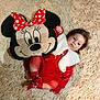 Dunja a rejoint le concours — aidez-le/la à gagner de superbes lots ! baby, child, plush_toy, minnie_mouse, red_dress, white_fur_collar, socks, soft_rug, curly_hair, indoor, lying_down, cute, holiday_outfit, cartoon_character, toy, face, person, cozy, smiling, comfort
