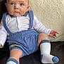 baby, child, infant, sitting, couch, leather, pillow, white_shirt, blue_suspender, blue_shorts, socks, cute, expression, indoor, furniture, person, portrait, young, skin, head