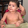 arm, baby, cheese_puffs, child, eating, expression, face, food, furniture, hair, hand, high_chair, indoor, messy, person, seat, skin, snack, table, toddler