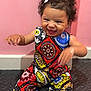 Bella joined the competition — help win amazing prizes! toddler, child, smile, happy, curly_hair, pink_bow, colorful_clothing, patterned_outfit, sitting, white_socks, indoor, floor, pink_wall, joyful, cute, young_child, portrait, baby, person, playful