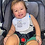 toddler, child, car_seat, smile, happy, baby, bib, clothing, sitting, seatbelt, green_shorts, face, person, infant, cute, indoors, safety_harness, young_child, portrait, joyful