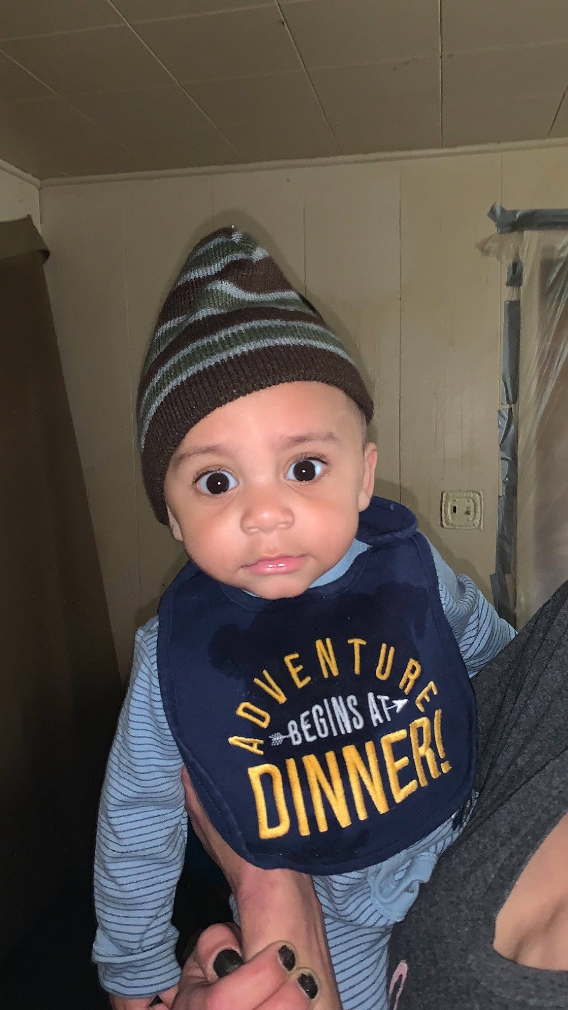James is registered to the contest to win money with this photo: baby, baby_toddler_clothing, beanie, cap, cheek, cool, elbow, eye, fashion_accessory, fun, headgear, headwear, human_body, knit_cap, long_sleeved_t_shirt, neck, person, sitting, sleeve, t_shirt