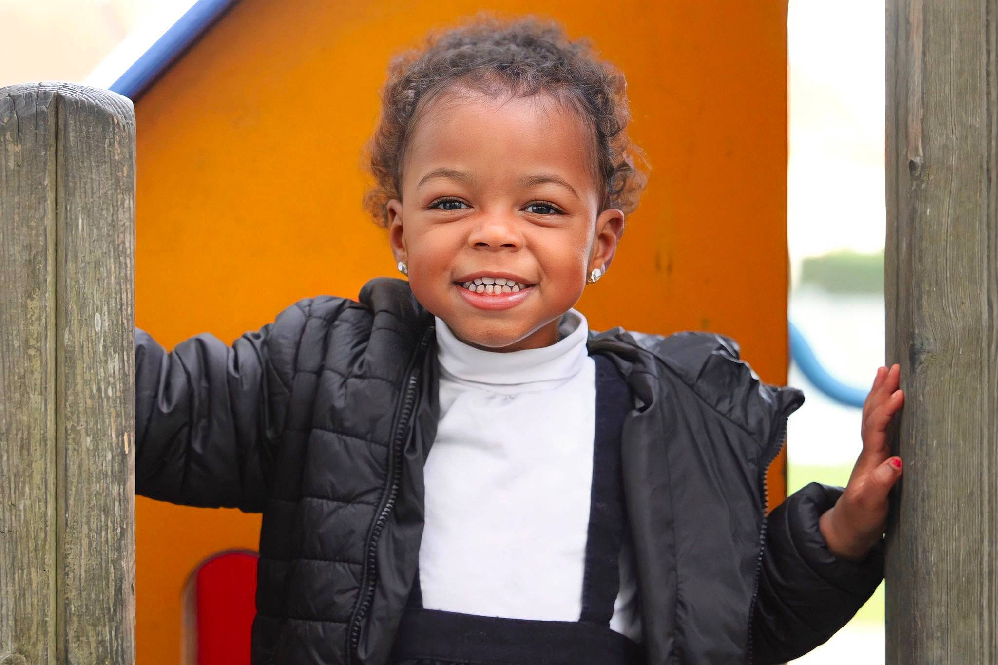Chelsea participe au concours pour gagner de l'argent avec cette photo : child, city, facial_expression, fun, gesture, happy, hoodie, jacket, joy, laugh, leisure, outdoor_play_equipment, person, play, portrait_photography, sleeve, smile, standing, t_shirt, thumb