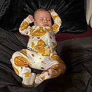 Stetson joined the competition — help win amazing prizes! baby, infant, sleeping, bed, bedding, onesie, clothing, portrait, indoors, face, eyes_closed, peaceful, lying_down, arms_raised, patterned_clothing, dark_background, home, photography, cozy, newborn