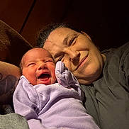 Rhonda joined the competition — help win amazing prizes! affection, baby, bond, candid, closeup, expression, family, happy, head, indoor, joy, lavender_clothing, love, newborn, portrait, skin, smile, tattoo, warm_lighting, woman