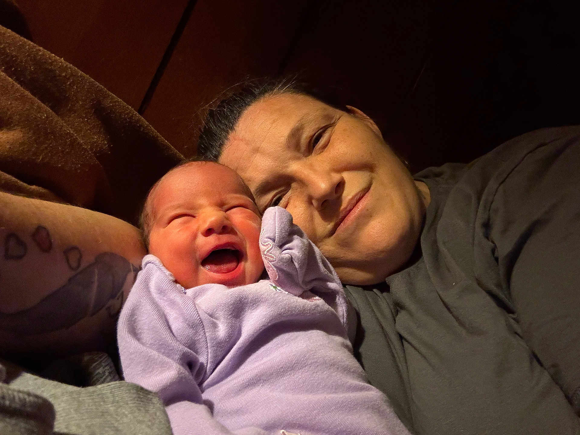Rhonda joined the competition — help win amazing prizes! affection, baby, bond, candid, closeup, expression, family, happy, head, indoor, joy, lavender_clothing, love, newborn, portrait, skin, smile, tattoo, warm_lighting, woman