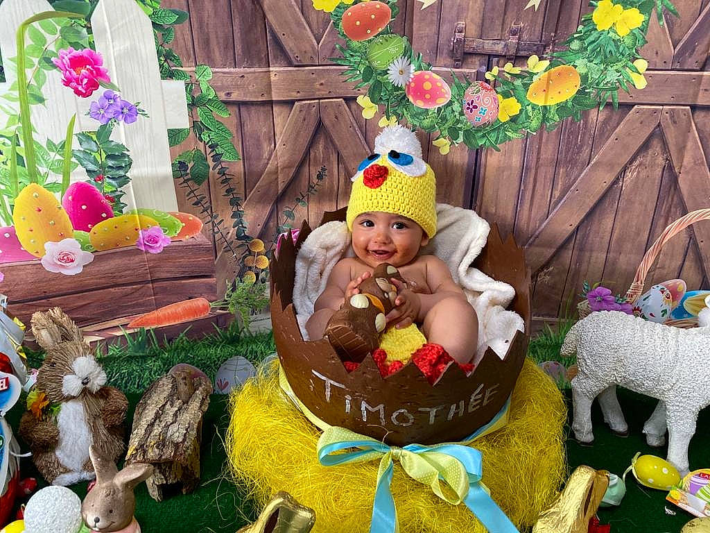 Timothée participe au concours pour gagner de l'argent avec cette photo : art, baby, baby_toddler_clothing, child, costume_hat, event, flower, fun, grass, happy, hat, headwear, holiday, joy, lawn_ornament, person, plant, room, sharing, smile