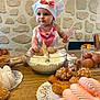 Ova participe au concours pour gagner de l'argent avec cette photo : baby, child, chef_hat, apron, flour, whisk, rolling_pin, baking, pastries, eggs, table, stone_wall, kitchen, cooking, dough, food, cute, smiling, indoors, gourmet
