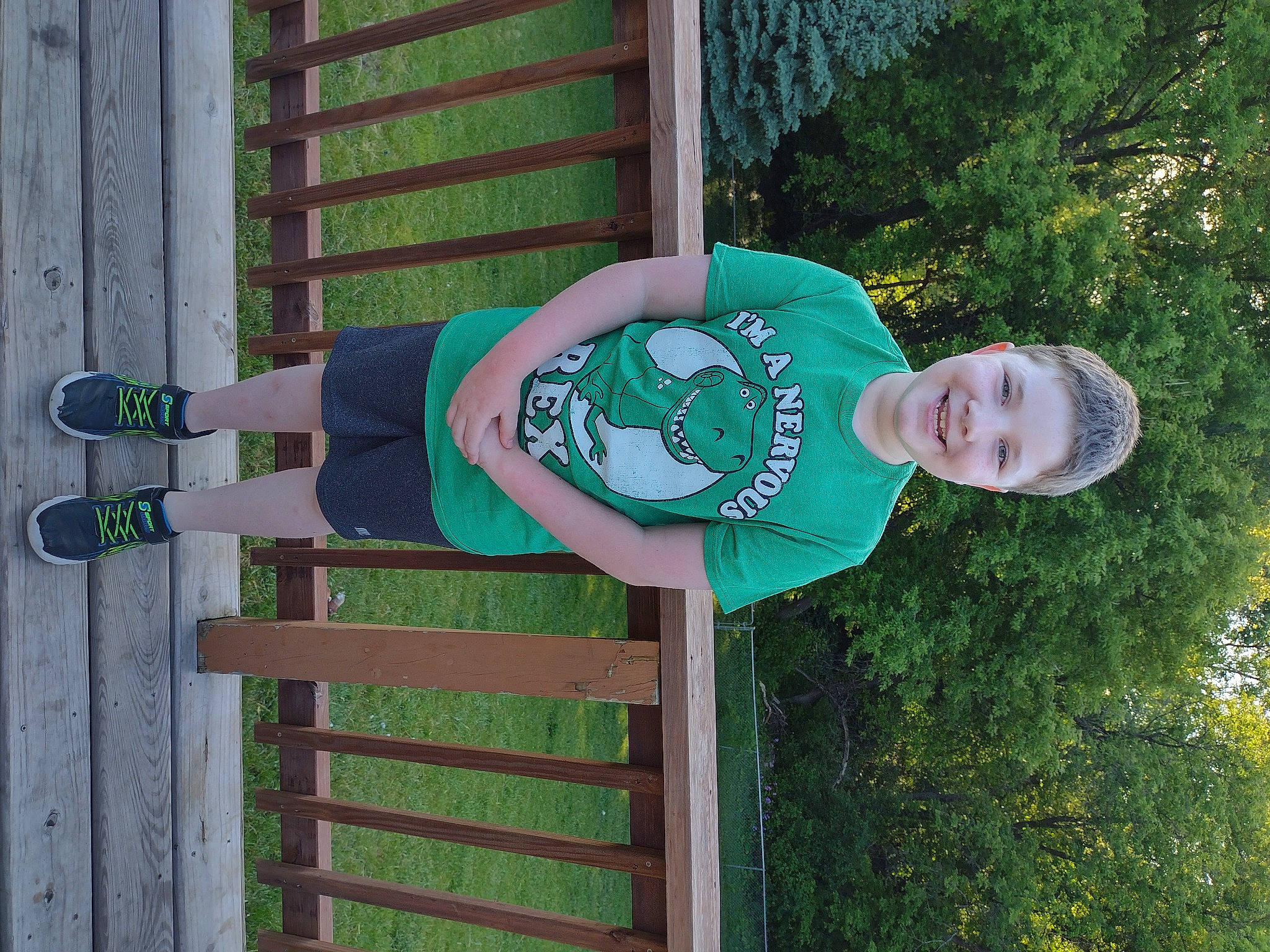 Mikey is registered to the contest to win money with this photo: fun, grass, happy, joy, leisure, person, plant, pole, smile, t_shirt, tree, walking_shoe, window, wood