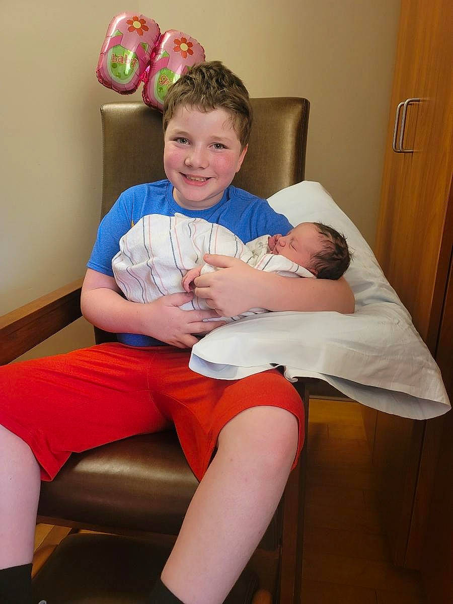 Mikey joined the competition — help win amazing prizes! chair, child, comfort, door, elbow, human_body, human_leg, joint, joy, knee, leg, muscle, person, shorts, shoulder, skin, smile, standing, stomach, thigh