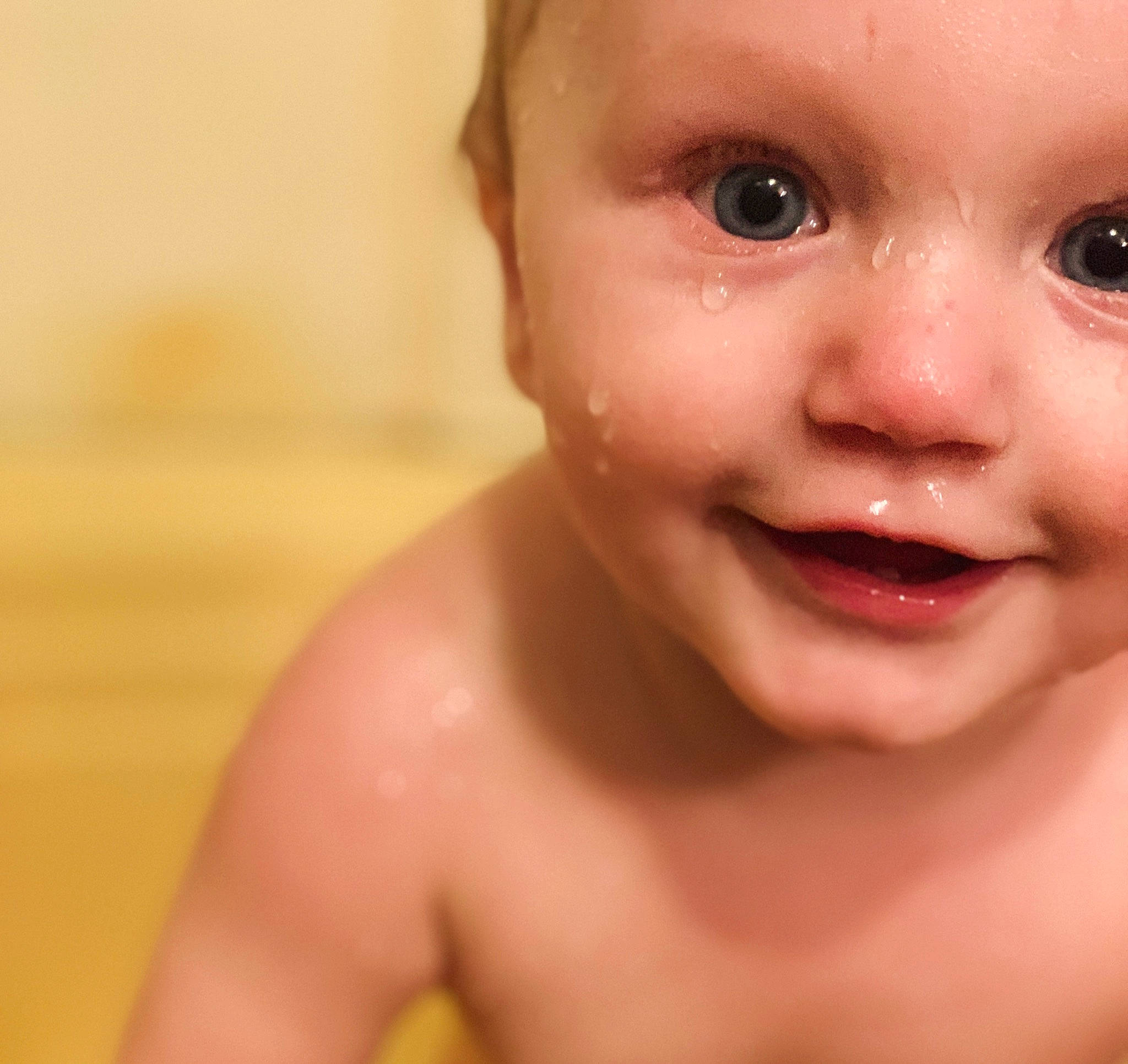 Desmond is registered to the contest to win money with this photo: baby, bathing, cheek, chest, close_up, disfigurement, ear, eye, eyelash, gesture, happy, human_body, iris, jaw, lip, neck, nose, person, smile, toddler