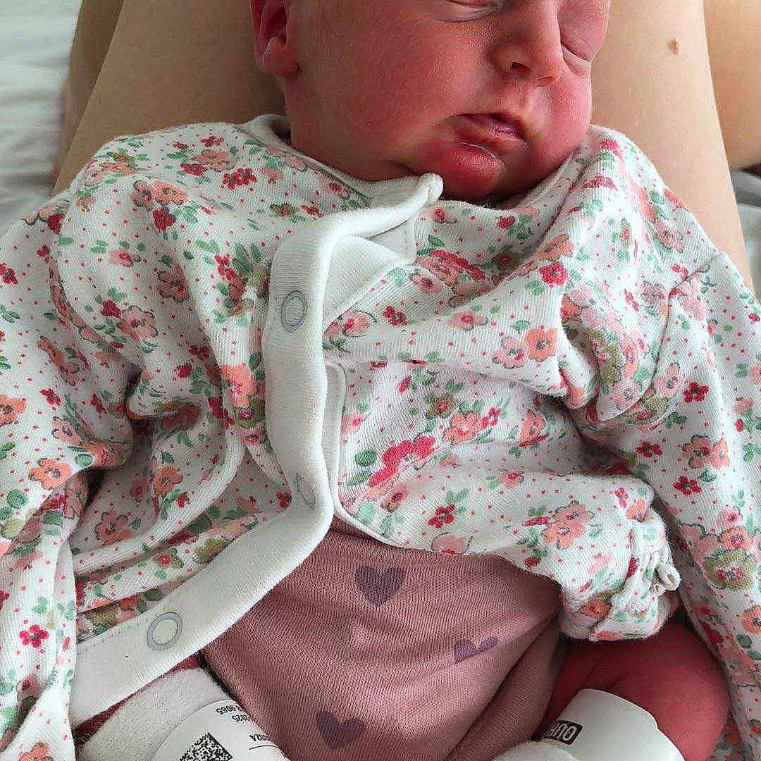 Carolynà is registered to the contest to win money with this photo: baby, bed, cozy, cute, feet, floral_clothing, hospital_band, human, indoors, infant, legs, newborn, peaceful, person, pink_pants, portrait, resting, skin, sleeping, toddler