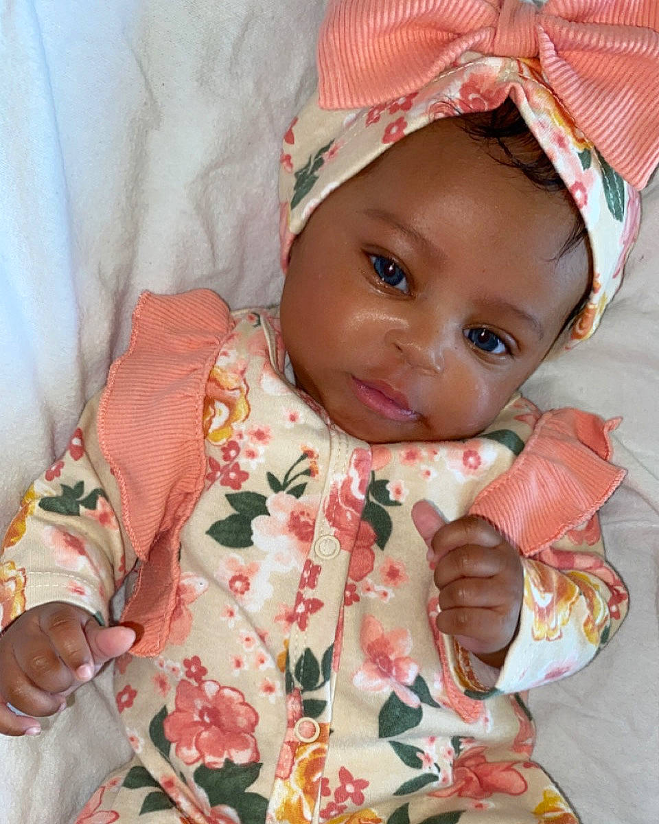 Aaminah is registered to the contest to win money with this photo: baby, baby_toddler_clothing, cheek, child, chin, dress, eye, face, happy, head, headgear, headwear, lip, mouth, nose, person, pink, skin, sleeve, smile