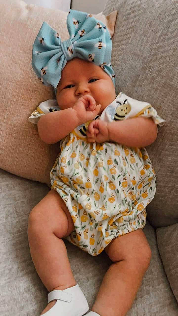 Honey is registered to the contest to win money with this photo: arm, baby, baby_toddler_clothing, cheek, child, comfort, face, facial_expression, finger, hand, happy, head, headwear, mammal, person, pink, skin, sleeve, textile, thigh