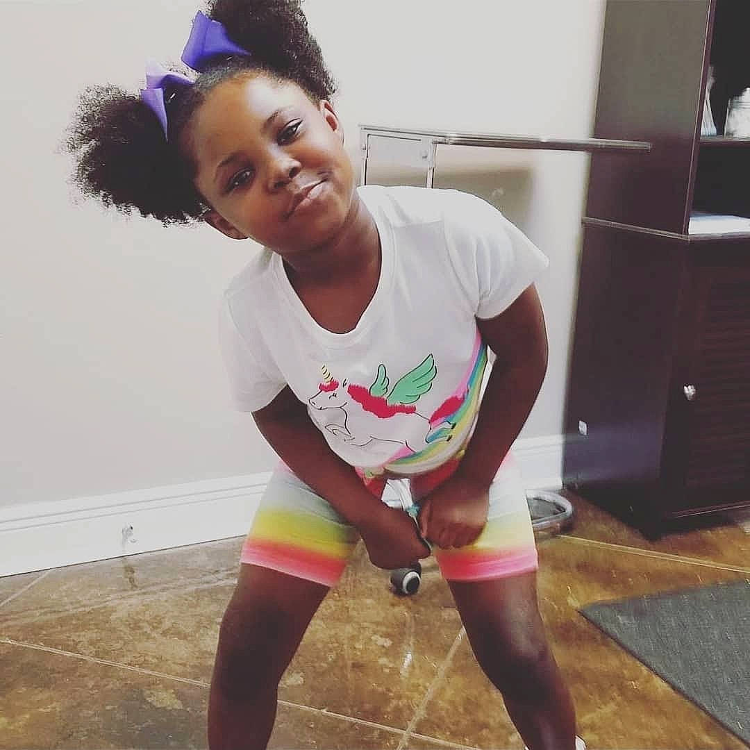 De'Asia is registered to the contest to win money with this photo: abdomen, active_pants, chest, face, floor, flooring, hairstyle, happy, human_leg, joint, joy, knee, neck, person, shorts, sleeve, sportswear, t_shirt, thigh, trunk