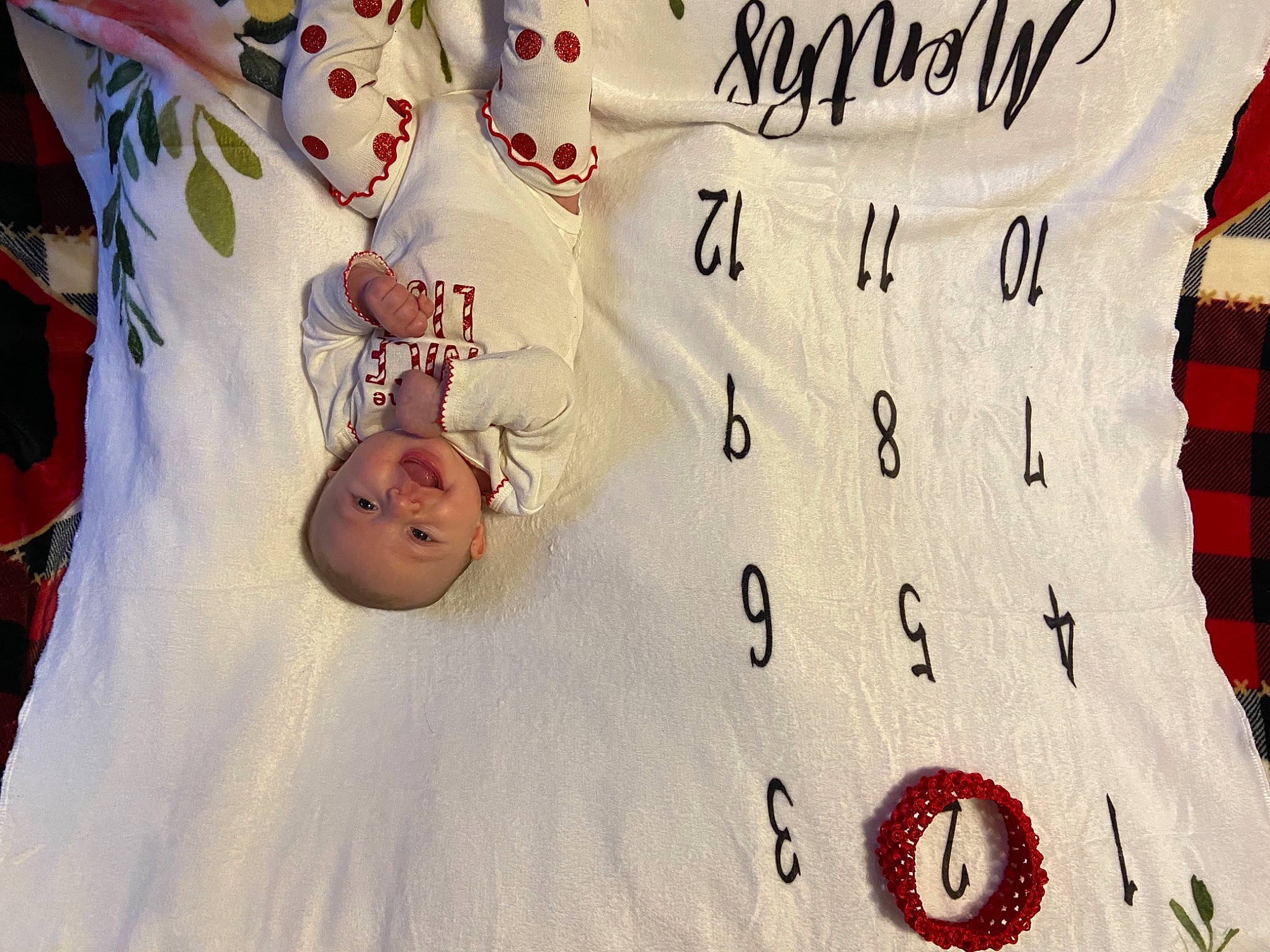 Brynleigh is registered to the contest to win money with this photo: baby, baby_toddler_clothing, bedding, carmine, coquelicot, facial_expression, linens, number, person, red, textile, white