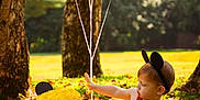 João Lucas joined the competition — help win amazing prizes! toddler, child, birthday_cake, balloons, outdoor, grass, trees, sunlight, red_clothing, headband, mickey_mouse_ears, wooden_crate, celebration, nature, fall_leaves, park, cute, baby, summer, playful