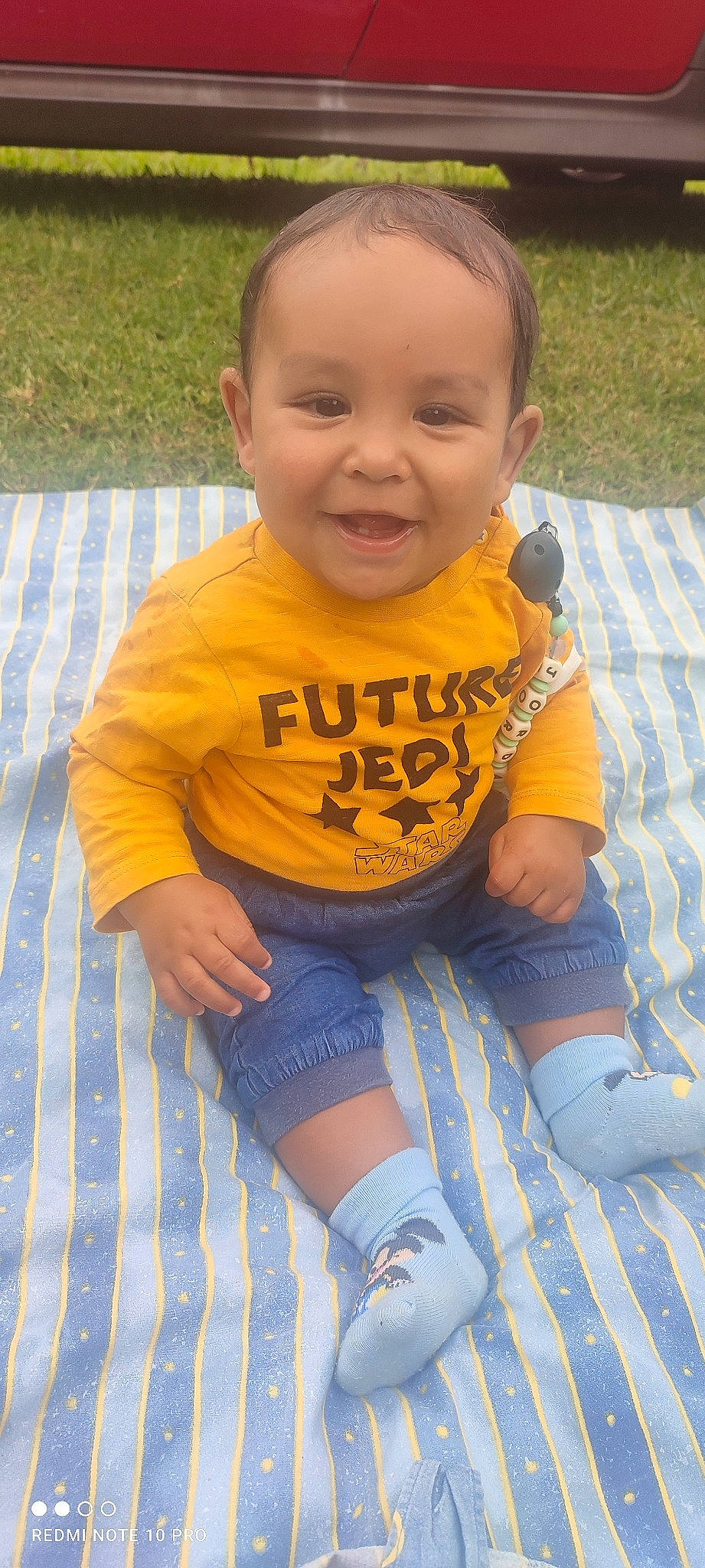 Jordan participe au concours pour gagner de l'argent avec cette photo : arm, baby_toddler_clothing, blue, chin, eye, face, finger, flooring, hair, hand, happy, head, human_body, leg, mouth, person, plant, skin, sleeve, smile