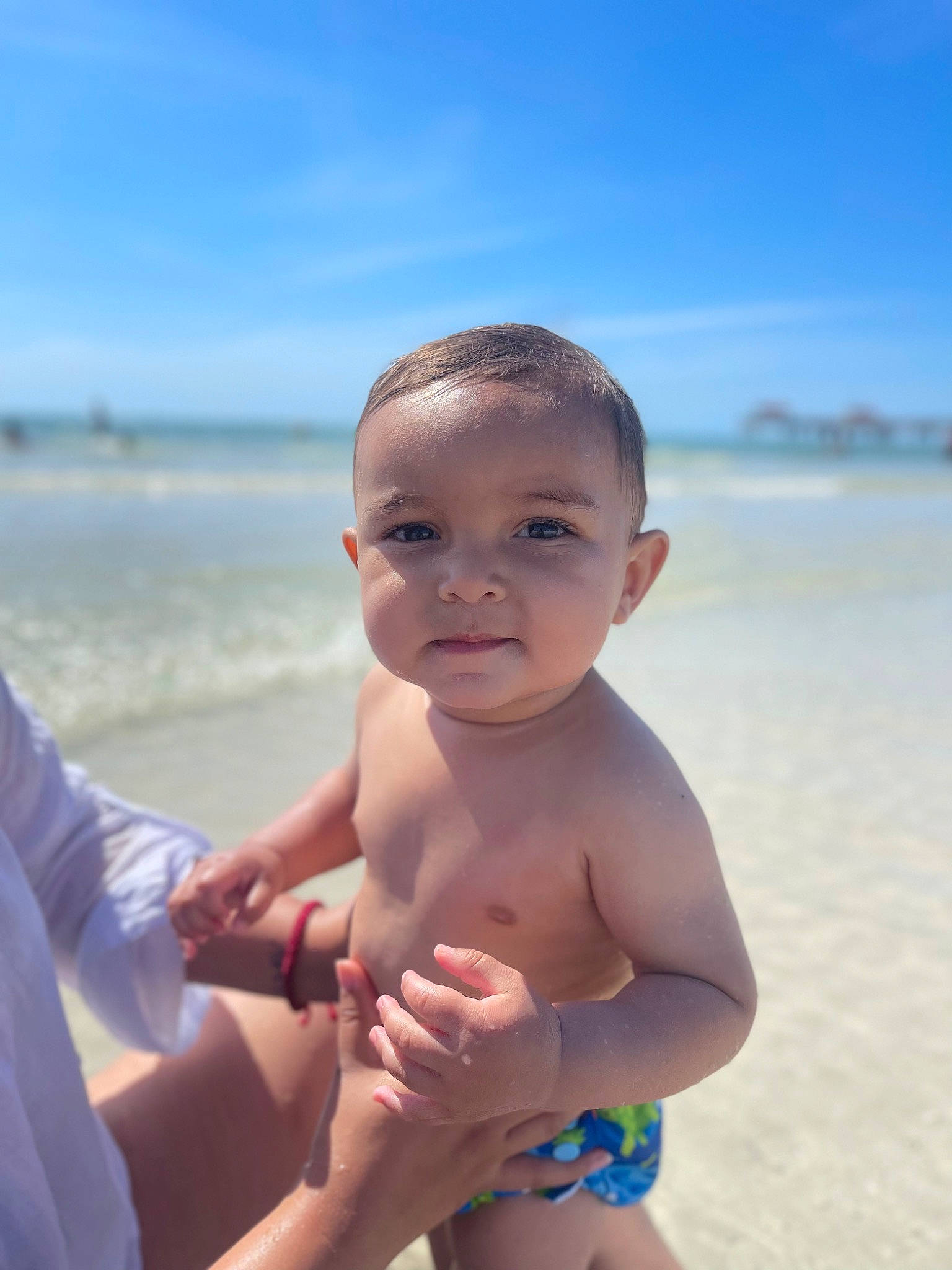 Kai is registered to the contest to win money with this photo: azure, baby, beach, cloud, face, flash_photography, fun, gesture, happy, leisure, muscle, people_in_nature, people_on_beach, person, skin, sky, stomach, thigh, thumb, toddler