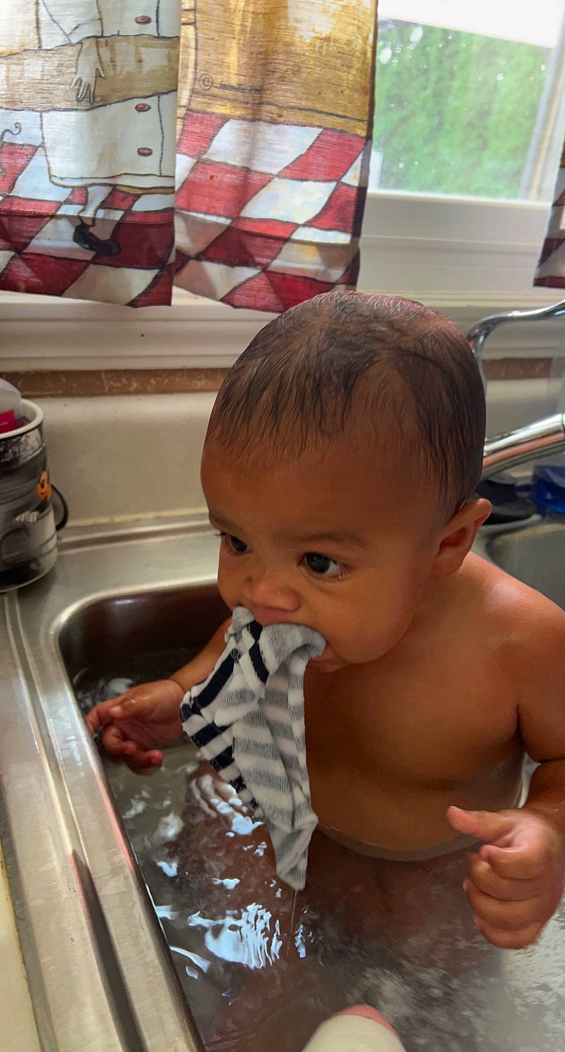 Micah is registered to the contest to win money with this photo: baby, baby_bathing, bathing, cheek, chest, child, cooking, fluid, fun, gas, hand, kitchen_sink, leisure, mouth, person, plumbing_fixture, sink, skin, toddler, vacation