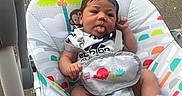 Zayvion joined the competition — help win amazing prizes! baby, baby_seat, cheeky, child, clothing, colorful, concrete, cute, expression, grass, infant, outdoor, patterned, person, playful, resting, seat, toddler, tongue_out, young