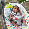 Zayvion joined the competition — help win amazing prizes! baby, infant, baby_seat, tongue_out, colorful, patterned, outdoor, concrete, grass, cute, cheeky, child, person, seat, playful, young, toddler, clothing, expression, resting