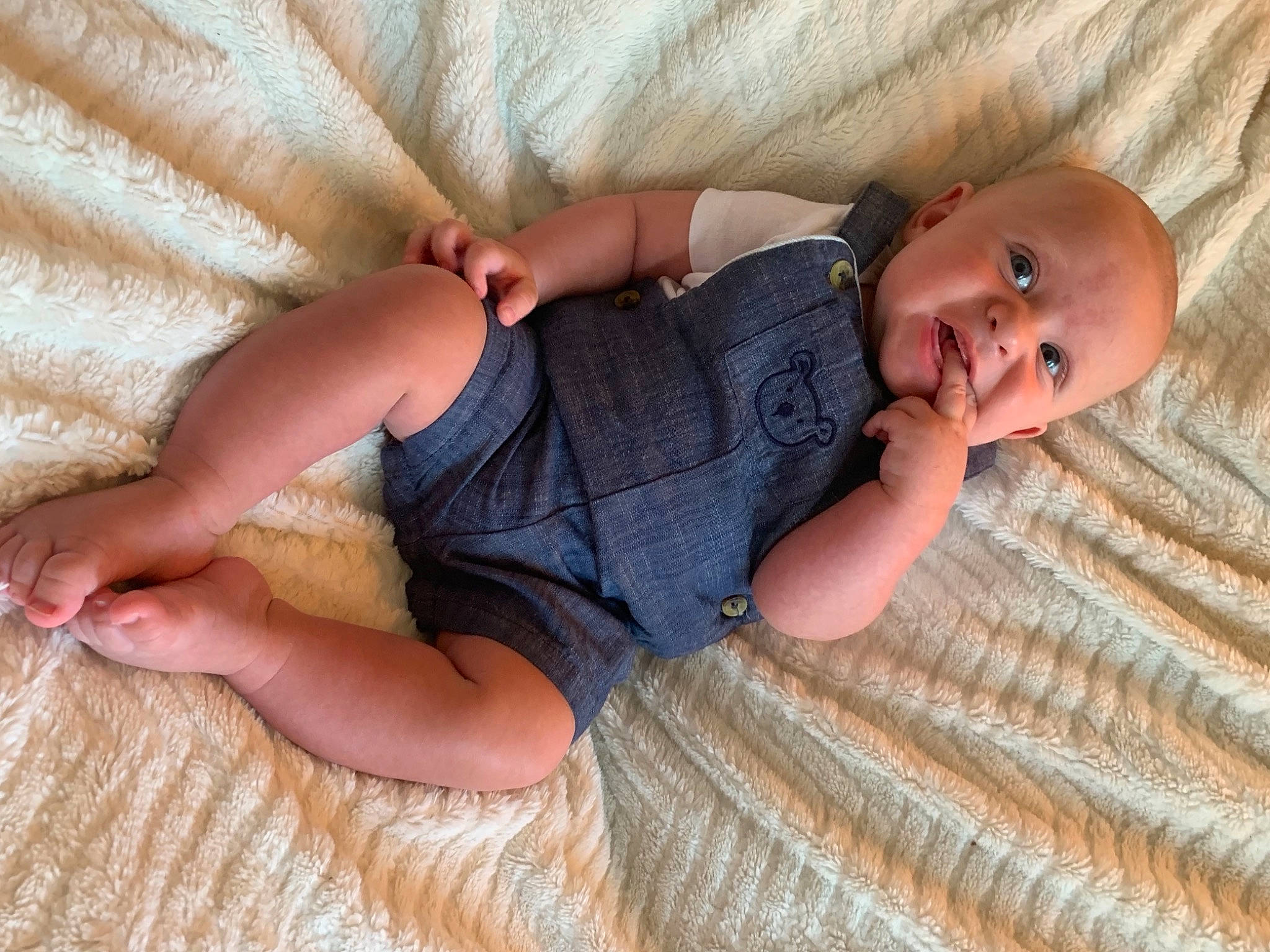 Finnegan is registered to the contest to win money with this photo: baby, baby_toddler_clothing, child, comfort, eye, fawn, finger, flooring, foot, grass, hardwood, head, human_leg, iris, linens, pattern, person, skin, toddler, vertebrate