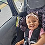 baby, child, car_seat, car_interior, seatbelt, smiling, headband, pink_clothing, mickey_mouse, minnie_mouse, happy, infant, safety_harness, road, window, vehicle, seat, toddler, cute, portrait