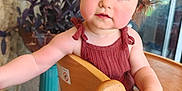 Ambre a rejoint le concours — aidez-le/la à gagner de superbes lots ! baby, brown_hair, casual_clothing, child, curious, cute, expression, face, high_chair, indoors, natural_light, plant, portrait, potted_plant, reaching_hand, sleeveless_top, stone_wall, toddler, wooden_chair, young_child