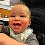 Miguel is registered to the contest to win money with this photo: baby, smiling, laughing, bib, high_chair, indoor, child, happy, face, person, clothing, hair, rosy_cheeks, seated, closeup, portrait, furniture, background, black_and_white_photo, expression