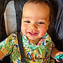toddler, child, smiling, happy, colorful_shirt, patterned_clothing, stroller, safety_strap, toy, cute, face, cheeks, eyes, hair, indoor, portrait, baby, seat, infant, playful