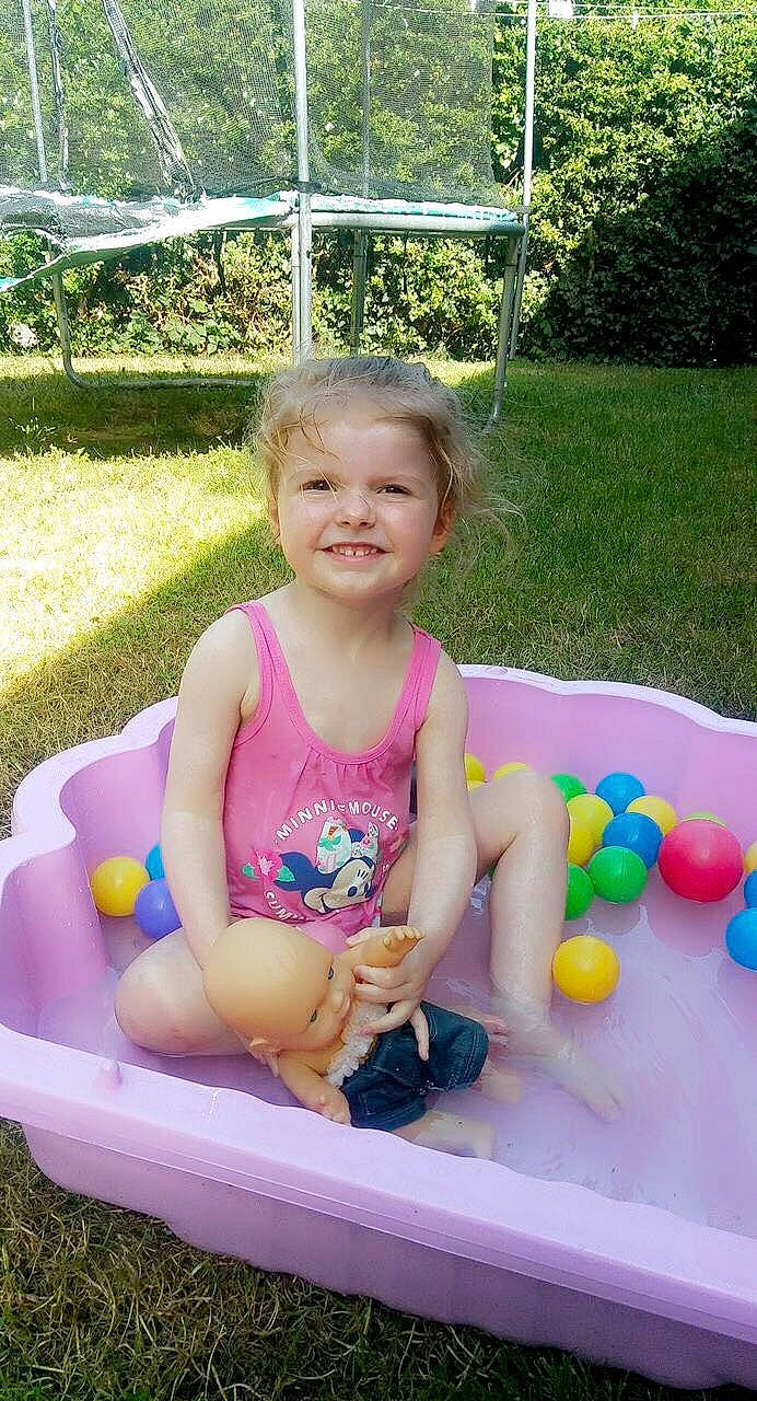 Anaé participe au concours pour gagner de l'argent avec cette photo : baby_products, baby_toddler_clothing, child, event, fun, grass, happy, joy, leisure, person, pink, plant, play, recreation, sitting, smile, summer, toddler, toy, tree