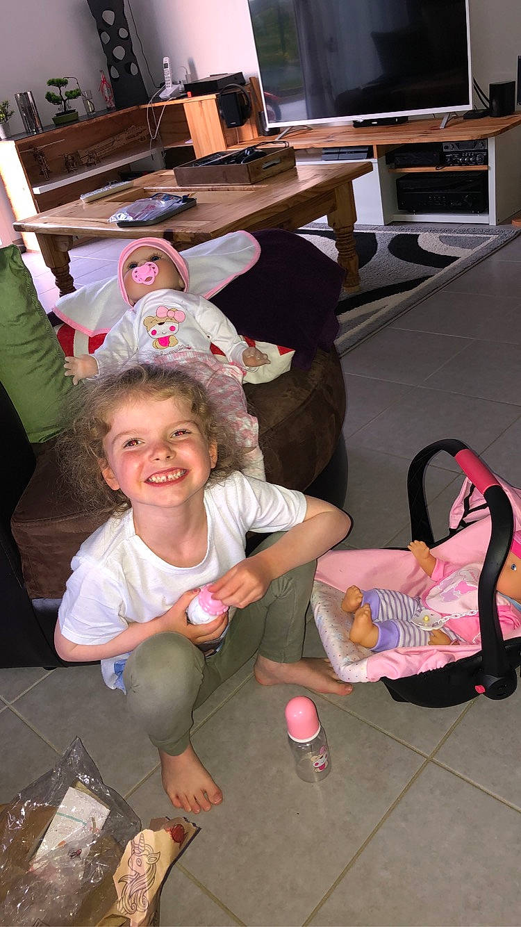 Anaé participe au concours pour gagner de l'argent avec cette photo : chair, child, desk, event, flooring, fun, happy, joy, lap, leisure, person, play, room, sandal, shorts, sitting, smile, sneakers, sock, t_shirt