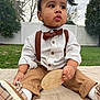 Matteo joined the competition — help win amazing prizes! baby, child, outdoor, grass, quilt, shirt, bow_tie, suspenders, pants, shoes, plaid, wooden_sign, eight_months, face, hands, sitting, curious, expression, fence, trees