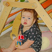 Diamantina joined the competition — help win amazing prizes! toddler, child, blue_eyes, toy_blocks, wooden_play_structure, indoor, floor, cushion, black_clothing, patterned_clothing, curious_expression, sitting, barefoot, light_skin, short_hair, earring, playtime, home, baby, cute