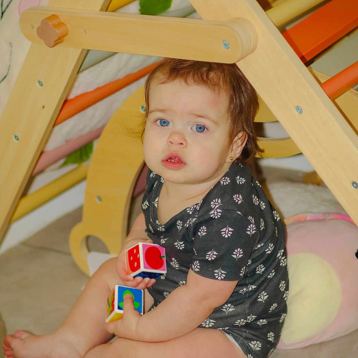 Diamantina joined the competition — help win amazing prizes! baby, barefoot, black_clothing, blue_eyes, child, curious_expression, cushion, cute, earring, floor, home, indoor, light_skin, patterned_clothing, playtime, short_hair, sitting, toddler, toy_blocks, wooden_play_structure
