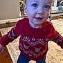 toddler, child, red_sweater, reindeer_pattern, indoor, carpet, wood_floor, christmas_tree, blur, motion, play_area, baby, person, home, holiday, festive, toy, furniture, smile, young_child