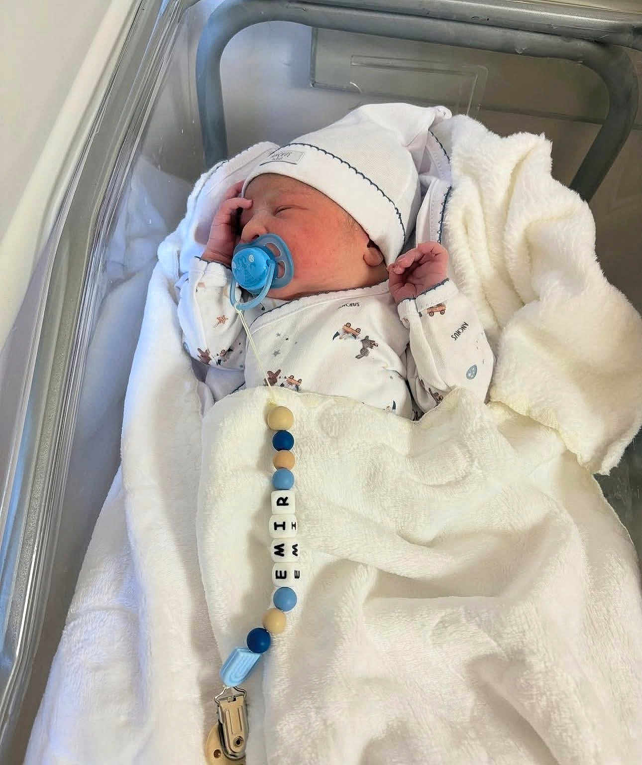 Jamiletze is registered to the contest to win money with this photo: newborn, baby, pacifier, blanket, hat, hospital_bassinet, sleeping, infant, clothing, beads, clip, cute, cozy, resting, child, indoors, person, white, soft, peaceful
