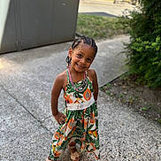 Këziah participe au concours pour gagner de l'argent avec cette photo : child, girl, smile, braided_hair, dress, sandals, outdoor, sidewalk, greenery, confident_pose, flower_pattern, happy, cute, portrait, sunlight, nature, fashion, accessories, young, casual