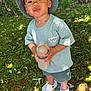 Braydenn participe au concours pour gagner de l'argent avec cette photo : toddler, child, bucket_hat, tshirt, green_clothing, shorts, sippy_cup, white_shoes, outdoor, grass, sunlight, nature, young_child, standing, curious_expression, summer, daylight, casual_clothing, playful, portrait