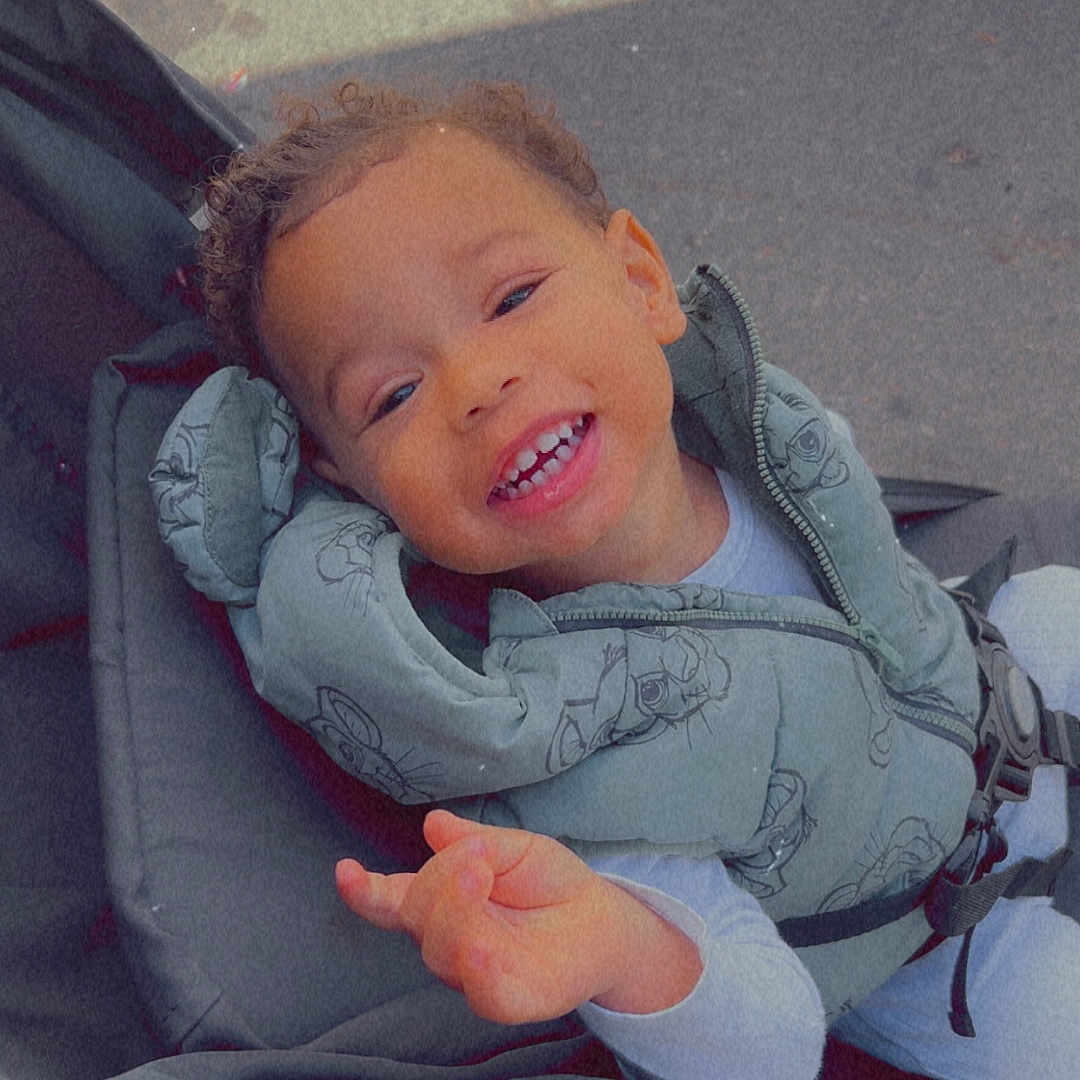 Braydenn a rejoint le concours — aidez-le/la à gagner de superbes lots ! baby, baby_wear, casual, child, clothing, curly_hair, cute, daylight, expression, happy, jacket, outdoor, person, playful, portrait, seat, smiling, stroller, toddler, young_child