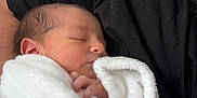 Samaël participe au concours pour gagner de l'argent avec cette photo : newborn, baby, blanket, sleeping, person, black_shirt, indoor, closeup, soft_texture, peaceful, infant, resting, wrapped, portrait, human, skin, hand, head, face, cozy