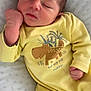 newborn, baby, sleeping, yellow_onesie, hippo_print, infant, cozy, soft_blanket, cute, peaceful, child, portrait, resting, small_hands, closed_eyes, indoors, cute_clothing, baby_fashion, young_child, comfortable