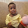 Chantel joined the competition — help win amazing prizes! baby, child, indoor, couch, yellow_clothing, toy, remote_control, face, smiling, sitting, curious, infant, happy, person, furniture, home, cute, young_child, plush_toy, relaxed