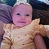 baby, smile, headband, yellow_outfit, infant, happy, face, person, closeup, indoor, child, cute, plush, sitting, portrait, soft_lighting, patterned_fabric, cozy, small_prints, young_child