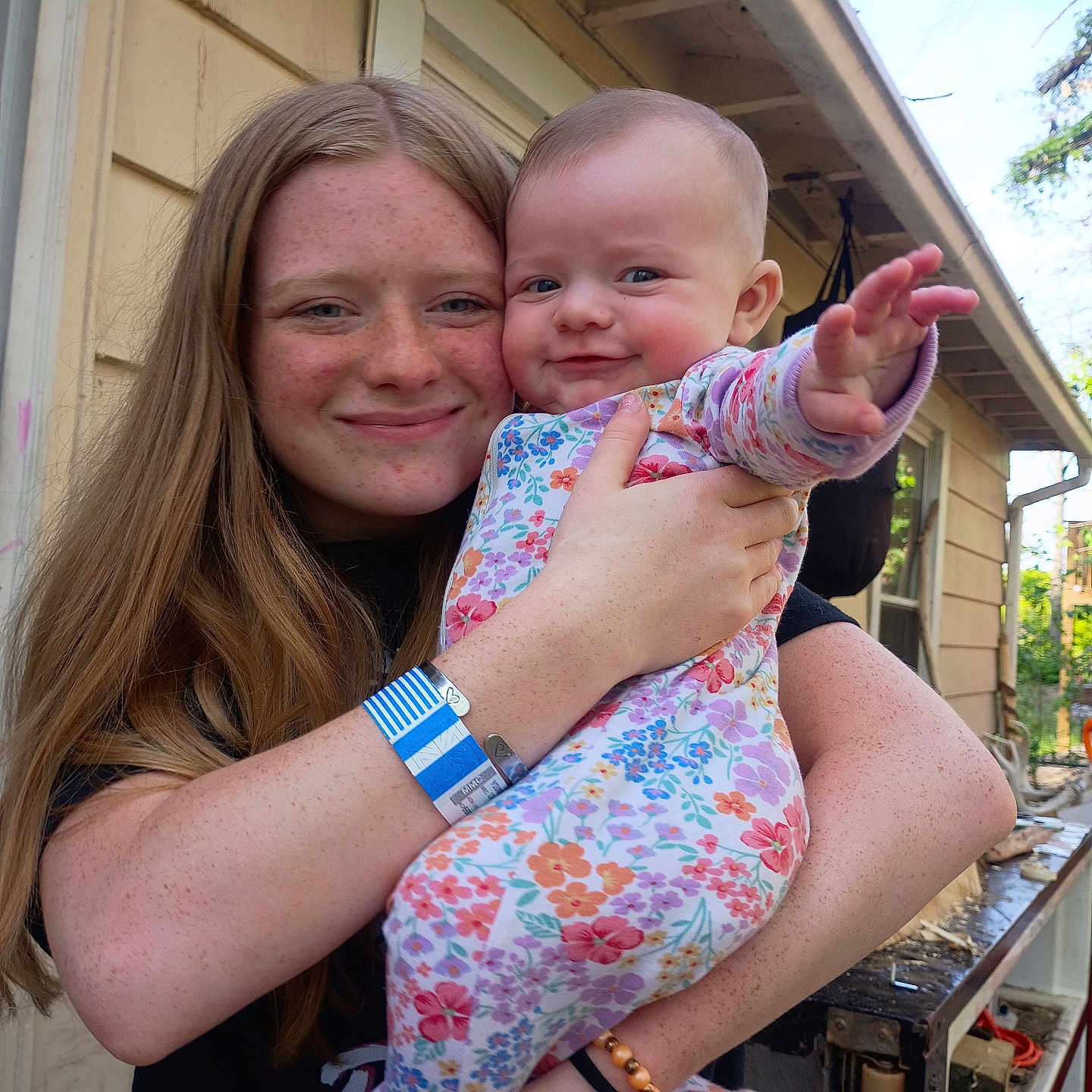 Sunniva joined the competition — help win amazing prizes! child, baby, girl, freckles, smile, outdoor, house, porch, long_hair, holding, colorful_clothing, happy, person, infant, family, casual, daylight, nature, toddler, portrait