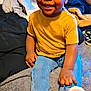 O'Mari joined the competition — help win amazing prizes! toddler, child, smiling, yellow_shirt, blue_jeans, brown_shoes, indoor, blanket, bedroom, casual, cute, portrait, person, footwear, curly_hair, young_child, sitting, cozy, home, clothing