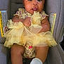 Eli'Yana is registered to the contest to win money with this photo: baby, child, car_seat, yellow_bow, tutu, socks, cute, infant, portrait, adorable, smiling, clothing, person, seatbelt, headwear, young_child, indoors, seat, happy, closeup